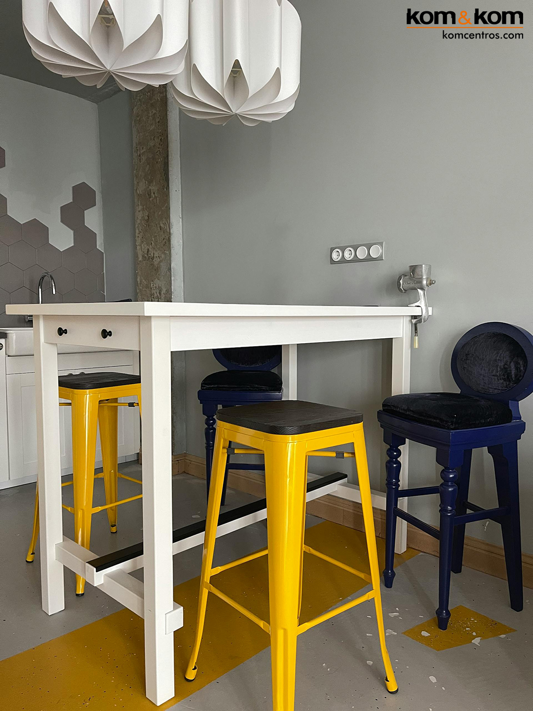 Taburetes de color azul y amarillo en mesa blanca de cocina